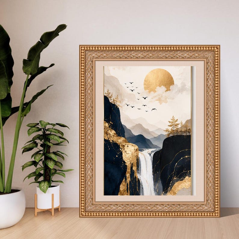 May include: A framed wall art print featuring a landscape with dark blue mountains, a white waterfall, and gold accents. The scene includes a large gold sun, silhouettes of birds in flight, and sparse trees against a pale, cloudy sky.