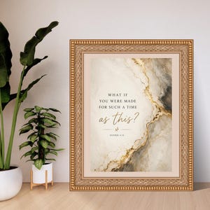 Op de afbeelding: Een ingelijste wandkunstprint met een abstracte, marmerachtige achtergrond in cr&egrave;me, grijs en goud met de tekst: WHAT IF YOU WERE MADE FOR SUCH A TIME as this? ESTHER 4:14. De lijst is sierlijk, goudkleurig en heeft een korrelige rand.