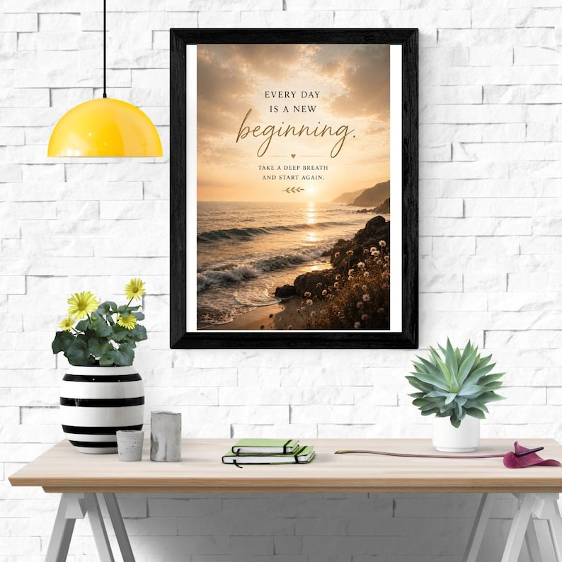 Może przedstawiać: Oprawiony wydruk ścienny przedstawiający krajobraz oceanu o zachodzie słońca z tekstem: EVERY DAY IS A NEW beginning. TAKE A DEEP BREATH AND START AGAIN. Obraz ukazuje fale uderzające o skalisty brzeg pod niebem w odcieniach złota i chmur.