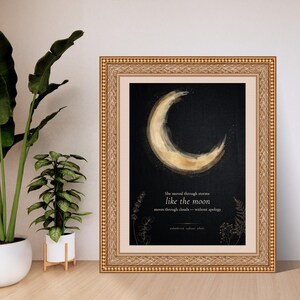 Pode incluir: Uma impress&atilde;o de arte emoldurada com uma lua crescente dourada sobre um fundo preto. O texto diz: She moved through storms like the moon moves through clouds &mdash; without apology, unbothered, radiant, whole. Delicados desenhos bot&acirc;nicos decoram a parte inferior.