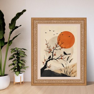 K&ouml;nnte beinhalten: Ein gerahmter Kunstdruck mit einer stilisierten Landschaft, einem gro&szlig;en orangefarbenen Sonnenkreis, einem blassen Mond und einem dunklen Ast mit roten Bl&uuml;ten. Zwei schwarze V&ouml;gel sitzen auf dem Ast, w&auml;hrend weitere V&ouml;gel am Himmel fliegen.