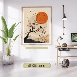 K&ouml;nnte beinhalten: Ein gerahmter Kunstdruck mit einer stilisierten Landschaft, einem gro&szlig;en orangefarbenen Sonnenkreis, einem bl&uuml;henden Ast mit zwei schwarzen V&ouml;geln und fliegenden V&ouml;geln vor beigem Hintergrund. Das Bild h&auml;ngt an einer wei&szlig;en Wand &uuml;ber einem Schreibtisch.