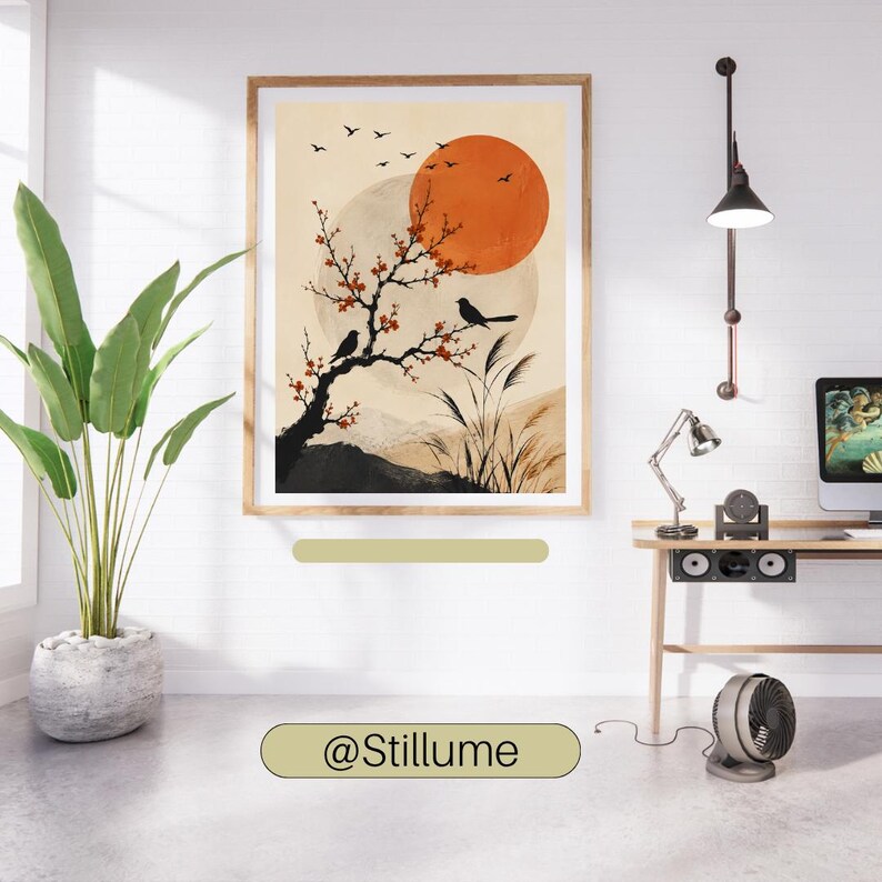 K&ouml;nnte beinhalten: Ein gerahmter Kunstdruck mit einer stilisierten Landschaft, einem gro&szlig;en orangefarbenen Sonnenkreis, einem bl&uuml;henden Ast mit zwei schwarzen V&ouml;geln und fliegenden V&ouml;geln vor beigem Hintergrund. Das Bild h&auml;ngt an einer wei&szlig;en Wand &uuml;ber einem Schreibtisch.