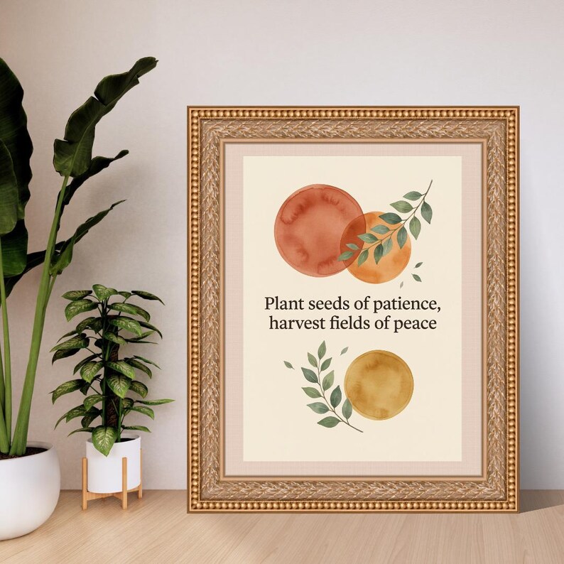 May include: A framed wall art print featuring watercolour circles in shades of terracotta, orange, and gold, accented with green leaf illustrations. The text reads, "Plant seeds of patience, harvest fields of peace," centred in a gold ornate frame.