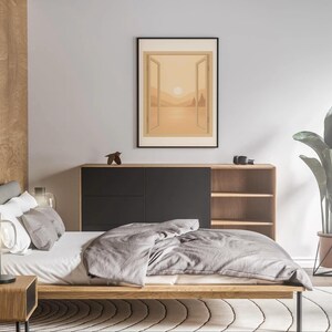 May include: A modern bedroom scene featuring a low wooden bed with gray bedding, a nightstand with a lamp, and a large framed artwork depicting a landscape. A wooden cabinet with black doors and open shelves is against the wall. A large potted plant adds a touch of nature.
