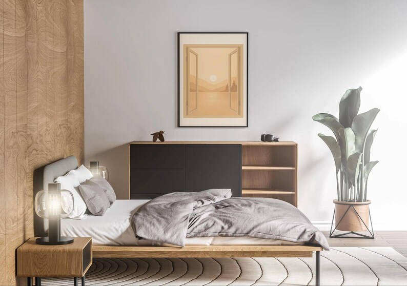 May include: A modern bedroom scene featuring a low wooden bed with gray bedding, a nightstand with a lamp, and a large framed artwork depicting a landscape. A wooden cabinet with black doors and open shelves is against the wall. A large potted plant adds a touch of nature.