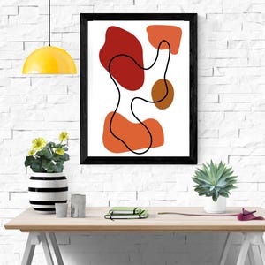 Può includere: Una stampa d'arte da parete incorniciata che presenta una composizione astratta di forme organiche in tonalità di rosso, arancione e marrone su sfondo bianco, sovrapposta da una linea nera continua che si curva al centro dell'opera.
