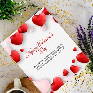 Può includere: Un biglietto di San Valentino con decorazioni a forma di cuore rosse e rosa. Il biglietto riporta la scritta "Happy Valentine's Day" e un messaggio sull'amore e le risate. Il biglietto è circondato da fiori e coriandoli dorati.
