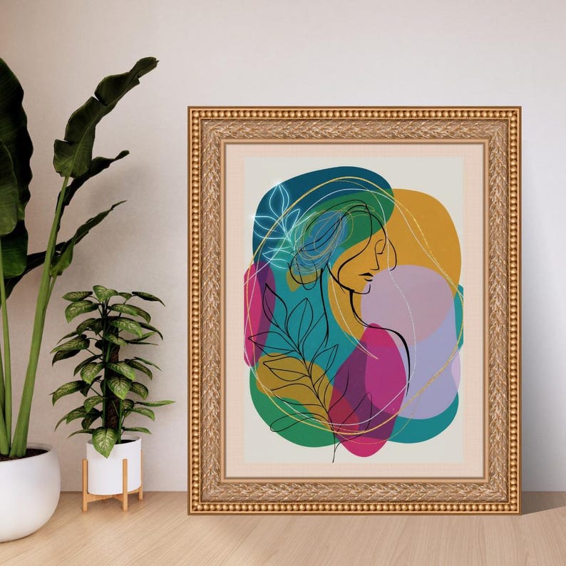 May include: Framed art print featuring a minimalist line drawing of a woman's profile, with colorful abstract shapes in teal, yellow, pink, and purple. The artwork is in a gold ornate frame, suitable for home decor.