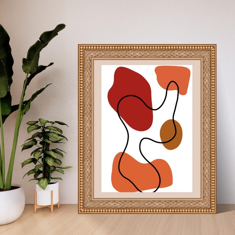 Puede incluir: Una l&aacute;mina de arte mural enmarcada con una composici&oacute;n abstracta sobre fondo blanco. El dise&ntilde;o incluye formas org&aacute;nicas s&oacute;lidas en tonos rojo intenso, naranja quemado y marr&oacute;n, superpuestas por una l&iacute;nea negra continua y curva.