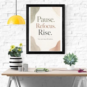 Peut inclure: Une affiche encadr&eacute;e avec le texte Pause. Refocus. Rise. et le texte plus petit Your next step still matters. Le design pr&eacute;sente des formes abstraites &agrave; l'aquarelle dans des tons vert, beige et terre cuite sur un fond cr&egrave;me.