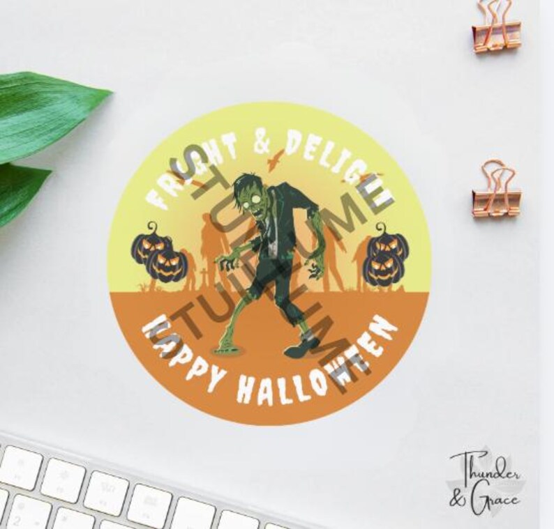 K&ouml;nnte beinhalten: Ein runder Aufkleber mit einem gr&uuml;nen Zombie in der Mitte, flankiert von zwei schwarzen K&uuml;rbislaternen auf jeder Seite. Der Hintergrund verl&auml;uft von Gelb zu Orange. Der Text lautet FRIGHT & DELIGHT und HAPPY HALLOWEEN in Wei&szlig;.