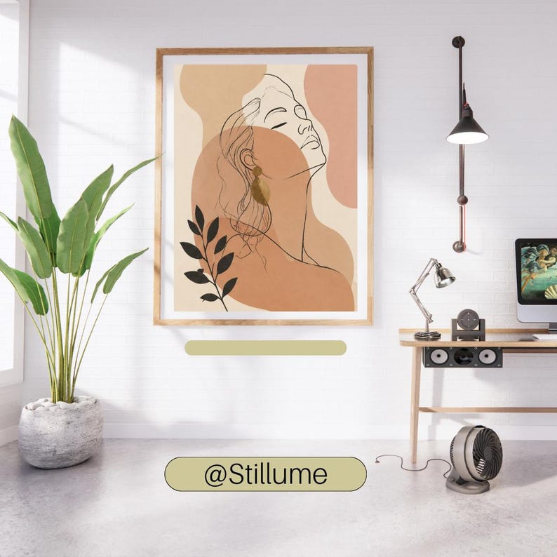 May include: A framed wall art print featuring a black line drawing of a person's profile against abstract shapes in shades of beige, tan, and terracotta. The artwork includes a black botanical illustration of leaves and the text @Stillume.