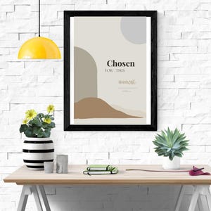 Può includere: Una stampa artistica da parete incorniciata con forme astratte in beige, marrone e grigio con il testo Chosen FOR THIS moment. La stampa è inserita in una cornice nera e presenta una composizione ispirata ai paesaggi con curve sovrapposte.