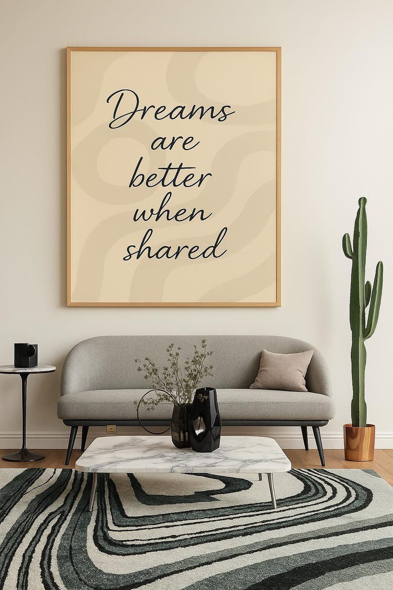 May include: A living room scene featuring a framed print with the text "Dreams are better when shared." A gray sofa, marble coffee table, and patterned rug are in front of a white wall. A tall cactus and black vase complete the decor.