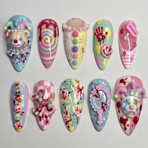 May include: A set of ten almond-shaped press-on nails featuring pastel colors and horror-themed embellishments. Designs include a 3D clown bear, blood drips, skulls, a broken mirror, a balloon animal, a razor blade, and a sad clown face.