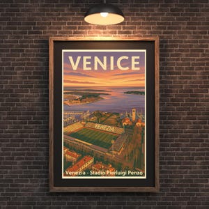 May include: Framed vintage travel poster of Venice, Italy, with the city name in large white letters at the top. The poster features a sunset over the water, a stadium, and the text "Venezia - Stadio Pierluigi Penzo" at the bottom.