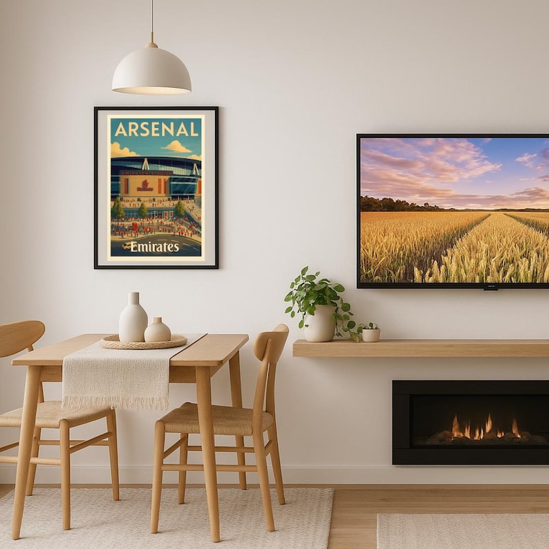 May include: A framed poster featuring the Arsenal stadium with the text "ARSENAL" at the top and "Emirates" at the bottom. The poster has a vintage travel poster style with a blue, beige, and red color scheme.