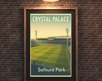 May include: A framed art print featuring a stylized illustration of Selhurst Park, home of Crystal Palace. The artwork depicts the stadium's exterior with a green field, blue seating, and the text "Crystal Palace" and "Selhurst Park".