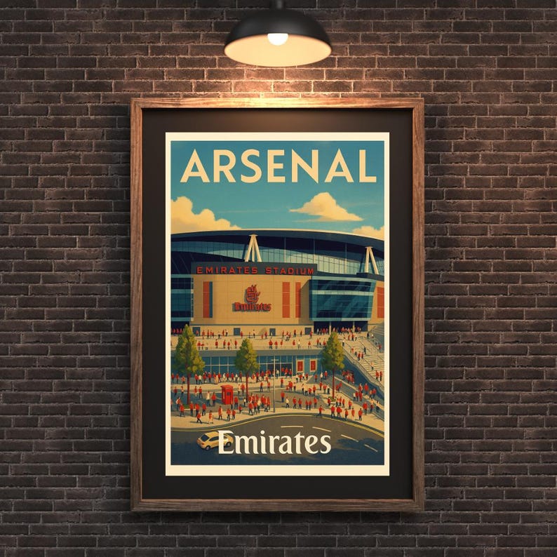 May include: Framed poster featuring the Arsenal Emirates Stadium. The poster has a vintage travel-style design with the word "ARSENAL" at the top and "Emirates" at the bottom. The stadium is depicted with a crowd of people and a blue sky.