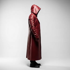 May include: A long, hooded, burgundy leather coat. The coat features a tailored fit, long sleeves, and a full-length design. The model is wearing black boots. The coat is a deep shade of red, with a glossy finish.