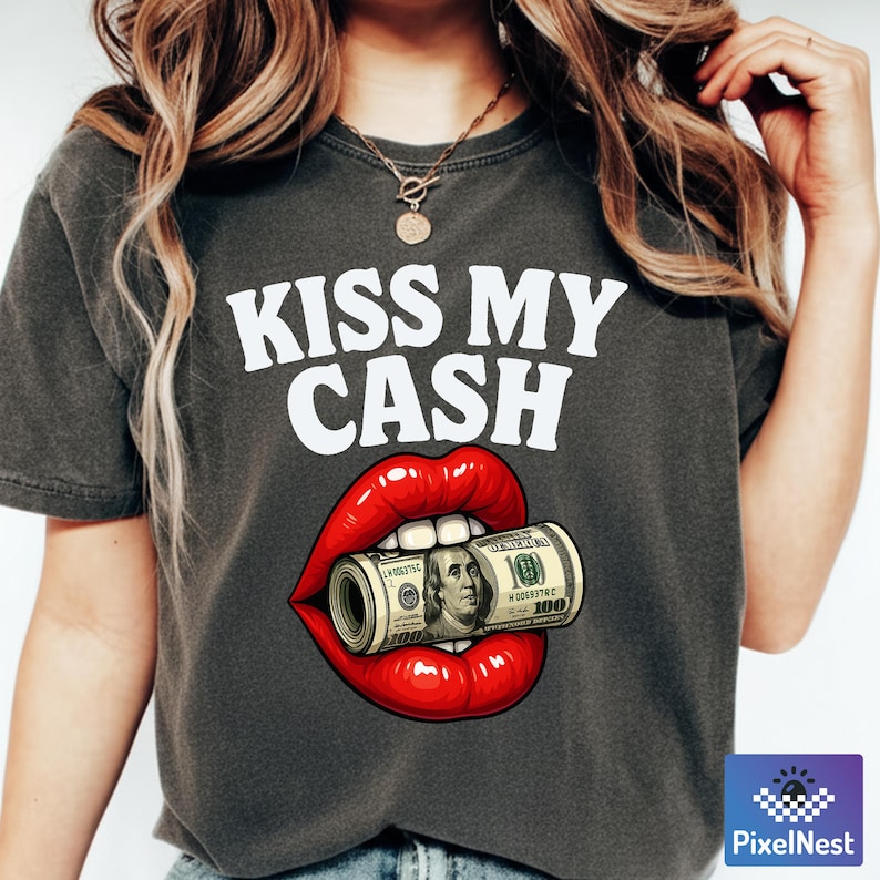 Pu&ograve; includere: T-shirt grigio scuro con la scritta bianca "KISS MY CASH". Il design presenta labbra rosse che tengono un rotolo di banconote da 100 dollari. La maglietta &egrave; un capo casual.