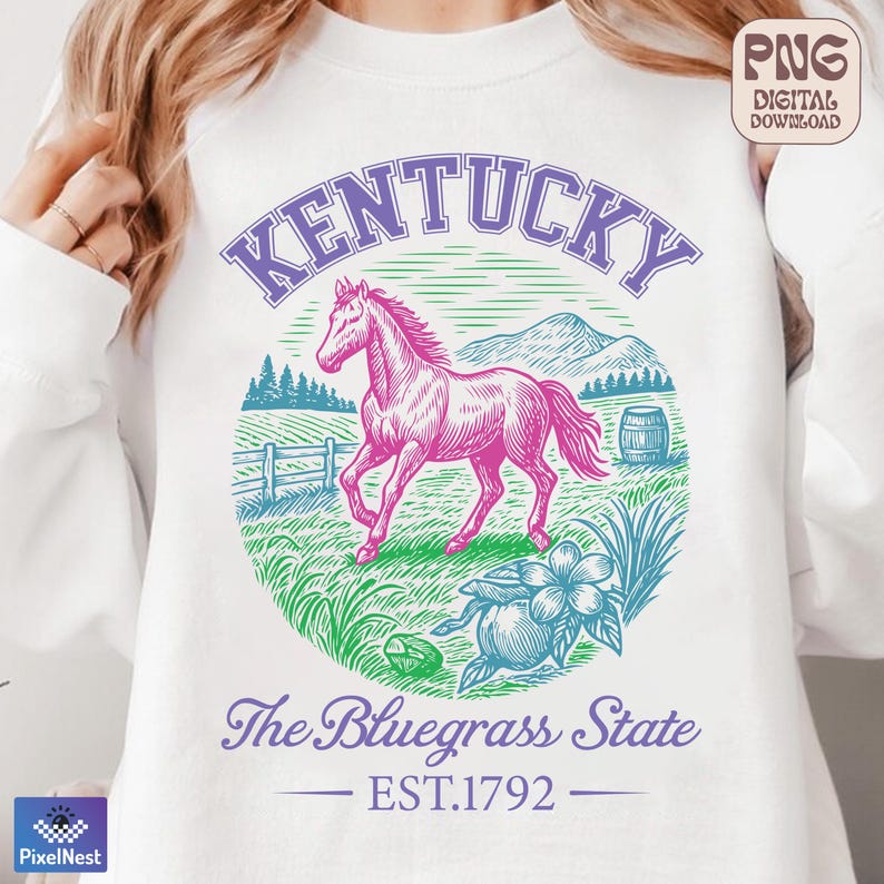 May include: White sweatshirt with a graphic design featuring a pink horse, the word "Kentucky" in purple, and the text "The Bluegrass State EST.1792". The design includes a fence, trees, and a flower.