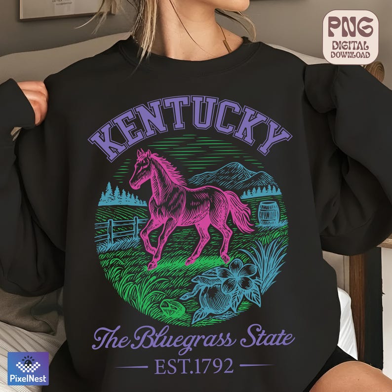 May include: Black sweatshirt with a graphic design featuring a pink horse, the word "Kentucky", and the text "The Bluegrass State EST.1792". The design includes a floral element and a barrel.