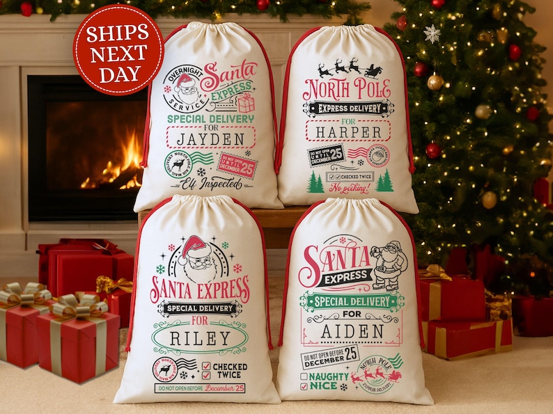 May include: Four white Christmas Santa sacks with red trim and drawstring closures. Each sack features festive graphics and text, including "Santa Express" and "North Pole Express" with names like "Jayden" and "Harper". A Christmas tree and fireplace are in the background.