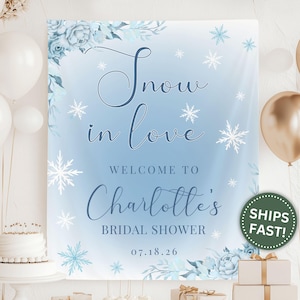 May include: A light blue bridal shower sign with the text "Snow in Love" and "Welcome to Charlotte's Bridal Shower". The sign features snowflake and floral accents, with the date 07.18.26.