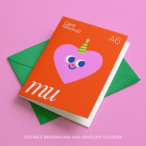 May include: An orange A6 card mockup featuring a pink heart character with a party hat, on a green envelope, set against a pink backdrop. The card displays the word "mu" in white script. The text "Card Mockup" and "A6" are also visible.