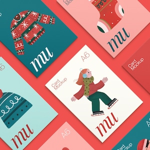 May include: A selection of A6 card mockups with festive winter designs. The cards display illustrations of a sweater, a stocking, a hat, and a person ice skating. Each card has the word "mu" and the text "Card Mockup".