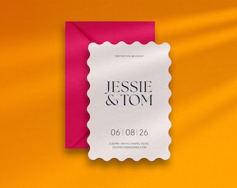 Può includere: Un biglietto d'invito bianco con bordo smerlato, con i nomi "Jessie & Tom" e la data "06|08|26". Una busta magenta è dietro il biglietto, su uno sfondo arancione.