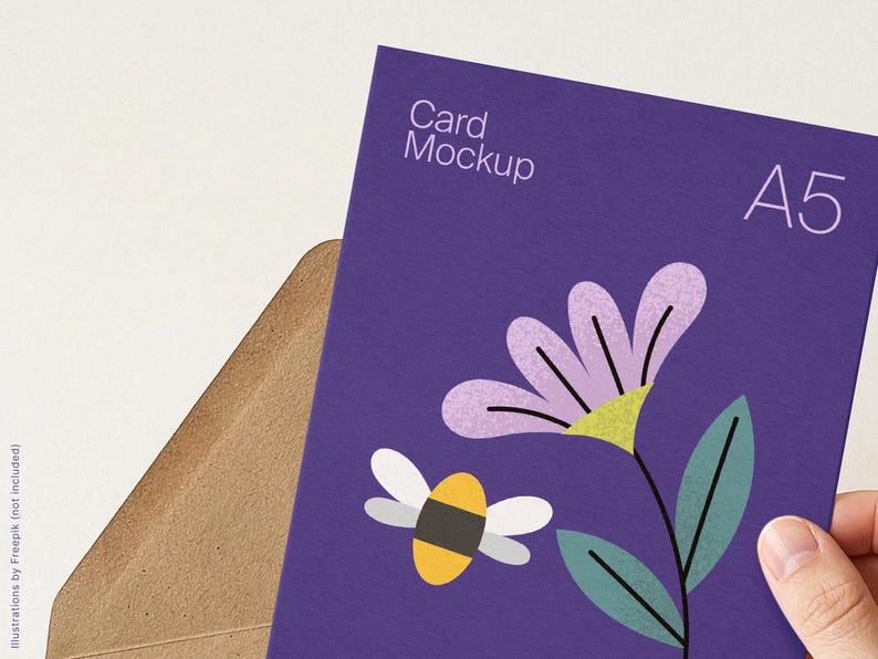 May include: A purple A5 card mockup with a floral and bee illustration. The card has the text "Card Mockup" and "A5" printed on it. The card is partially inserted into a brown envelope.