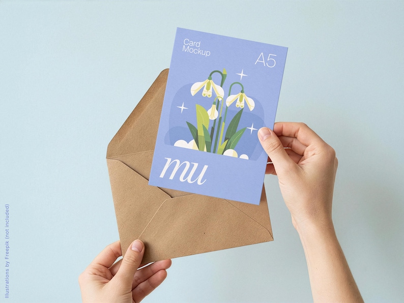 May include: A5 card mockup with a floral illustration and the word "mu" in a light blue envelope. The card features a design of white flowers with green leaves. The background is a light blue.