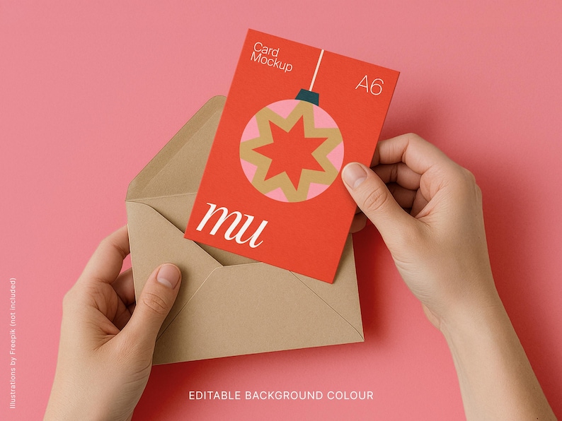 May include: A red A6 card mockup with a Christmas ornament design is held in a brown envelope against a pink background. The card features a gold and pink starburst design and the letters "mu". The words "Card Mockup" and "A6" are also visible.