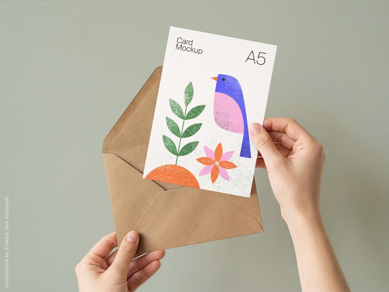 May include: A5 card mockup featuring a colorful bird illustration with a pink body, blue wing, and orange beak. The card is held in a brown envelope. The card also features a green plant and orange flower.