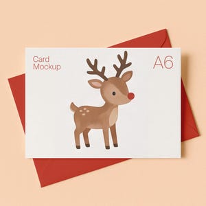 May include: A white A6 card mockup featuring a brown reindeer illustration with a red nose and antlers, positioned on a red envelope. The text Card Mockup and A6 are printed on the card. The design displays a simple, clean aesthetic.