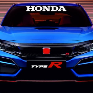 Op de afbeelding: Een felblauwe Honda Civic Type R auto. Het woord "HONDA" staat in het wit bovenaan de voorruit. De voorkant van de auto heeft een rood Honda-embleem en de merknaam "TYPE R".
