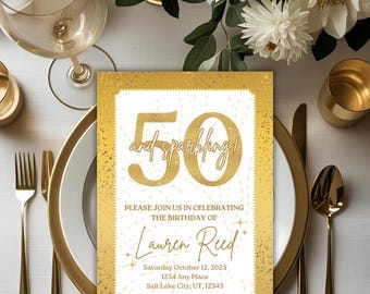 May include: A gold and white 50th birthday invitation with the text "50 and sparkling!" and event details. The invitation is on a table setting with gold cutlery, plates, and a wine glass. White flowers are in the background.