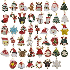 May include: Assortment of gold-tone Christmas charm pendants with enamel details.  The charms feature various holiday themes, including Santa Claus, reindeer, snowmen, candy canes, Christmas trees, and ornaments.