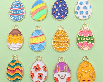 May include: Twelve gold-tone metal charms shaped like Easter eggs with various colorful enamel designs. The designs include stripes, polka dots, flowers, a chick, a bunny, and geometric patterns.