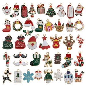 May include: Assortment of 36 gold-tone metal Christmas charm pendants. The charms feature various holiday themes, including Santa Claus, reindeer, snowmen, candy canes, Christmas trees, stockings, wreaths, and gift boxes. The charms are decorated with colorful enamel paint.