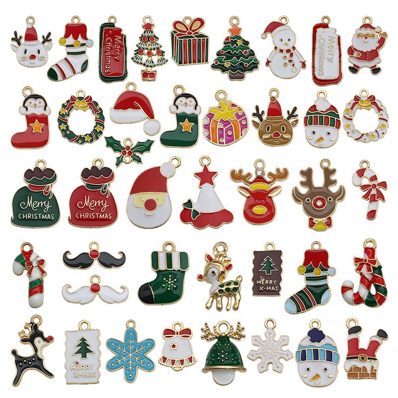 May include: Assortment of 36 gold-tone metal Christmas charm pendants. The charms feature various holiday themes, including Santa Claus, reindeer, snowmen, candy canes, Christmas trees, stockings, wreaths, and gift boxes. The charms are decorated with colorful enamel paint.