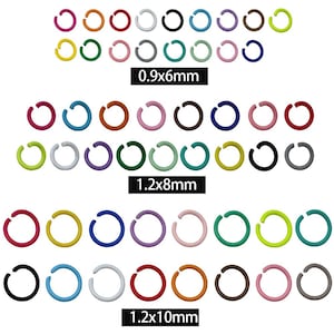 Puede incluir: Una colección de anillas de salto abiertas multicolores dispuestas en tres filas distintas, etiquetadas con los tamaños 0.9x6mm, 1.2x8mm y 1.2x10mm. Las anillas se presentan en varios colores sólidos, incluyendo rojo, azul, verde, amarillo, rosa, negro y blanco.