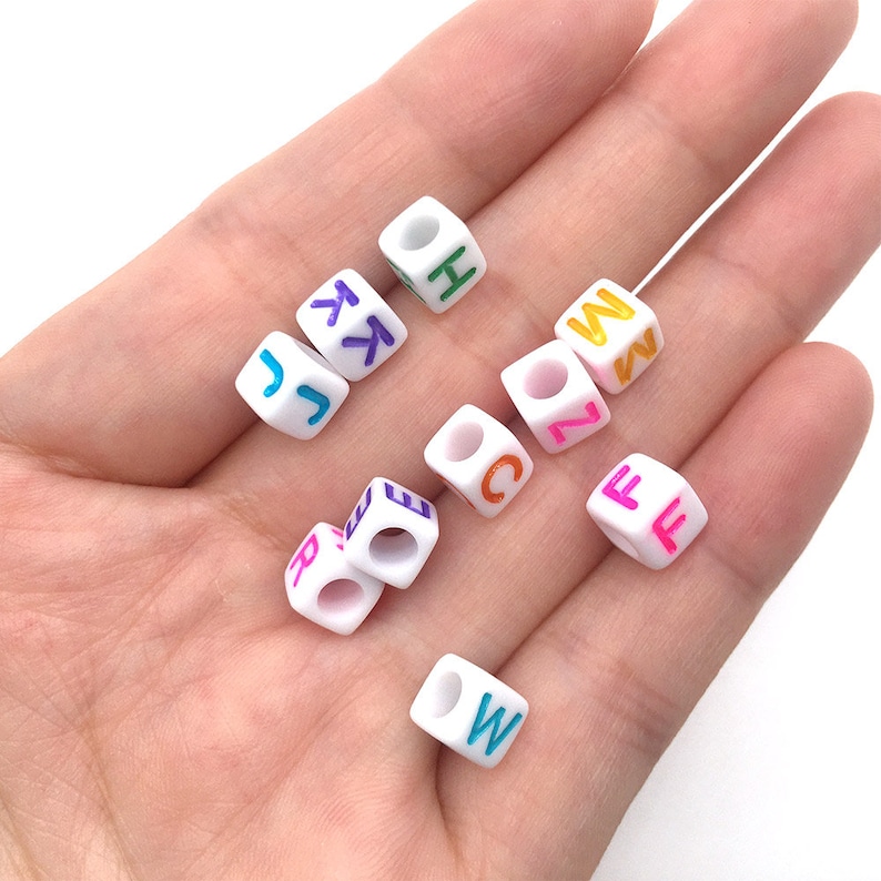 May include: White plastic letter beads with colorful letters. The letters are J, K, L, H, C, Z, M, N, E, R, F, W.