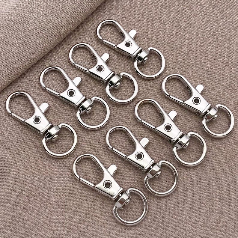 May include: A set of eight silver keychains with a simple, classic design. Each keychain features a sturdy, durable metal loop and a secure clasp.