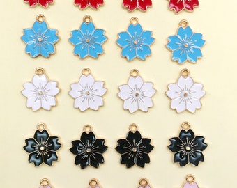 May include: Twenty gold-tone metal charms shaped like five-petal flowers. The charms are in five colors: red, blue, white, black, and pink.