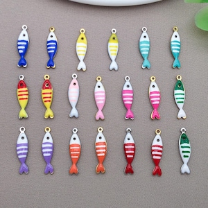 May include: A collection of colorful fish-shaped charms. Each charm features a white base with stripes and a contrasting tail fin. The charms are in various colors, including blue, yellow, pink, red, orange, purple, and green, with gold-colored loops.
