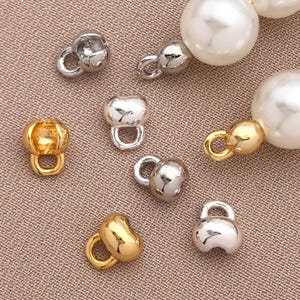 May include: Assortment of gold, silver, and white metal clasps for jewellery making. The clasps are round and have a small loop on one side. They are perfect for adding a touch of elegance to necklaces, bracelets, and other jewellery pieces.